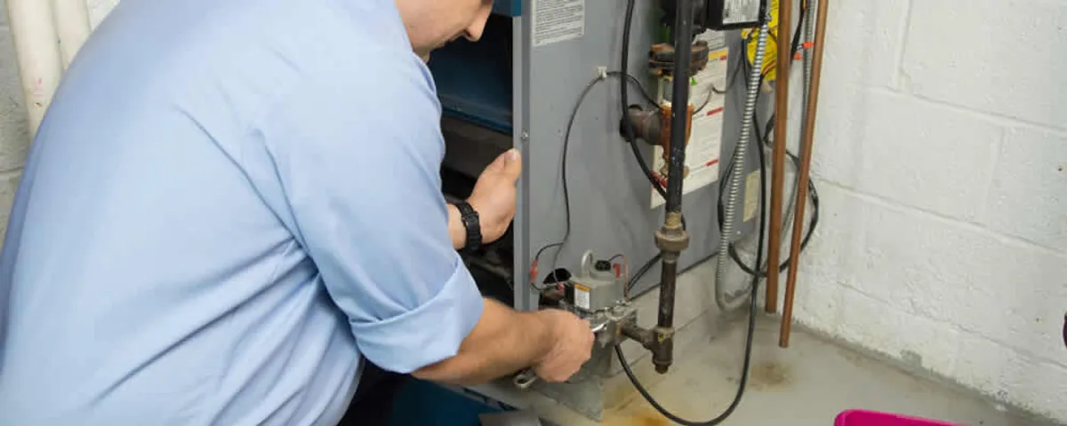 Furnace repair technician inspecting and servicing a home heating system in San Antonio, TX