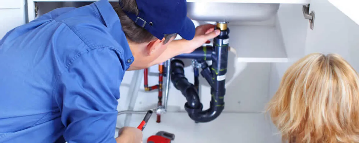 Plumber repairing under-sink drain pipes and fittings in San Antonio, TX